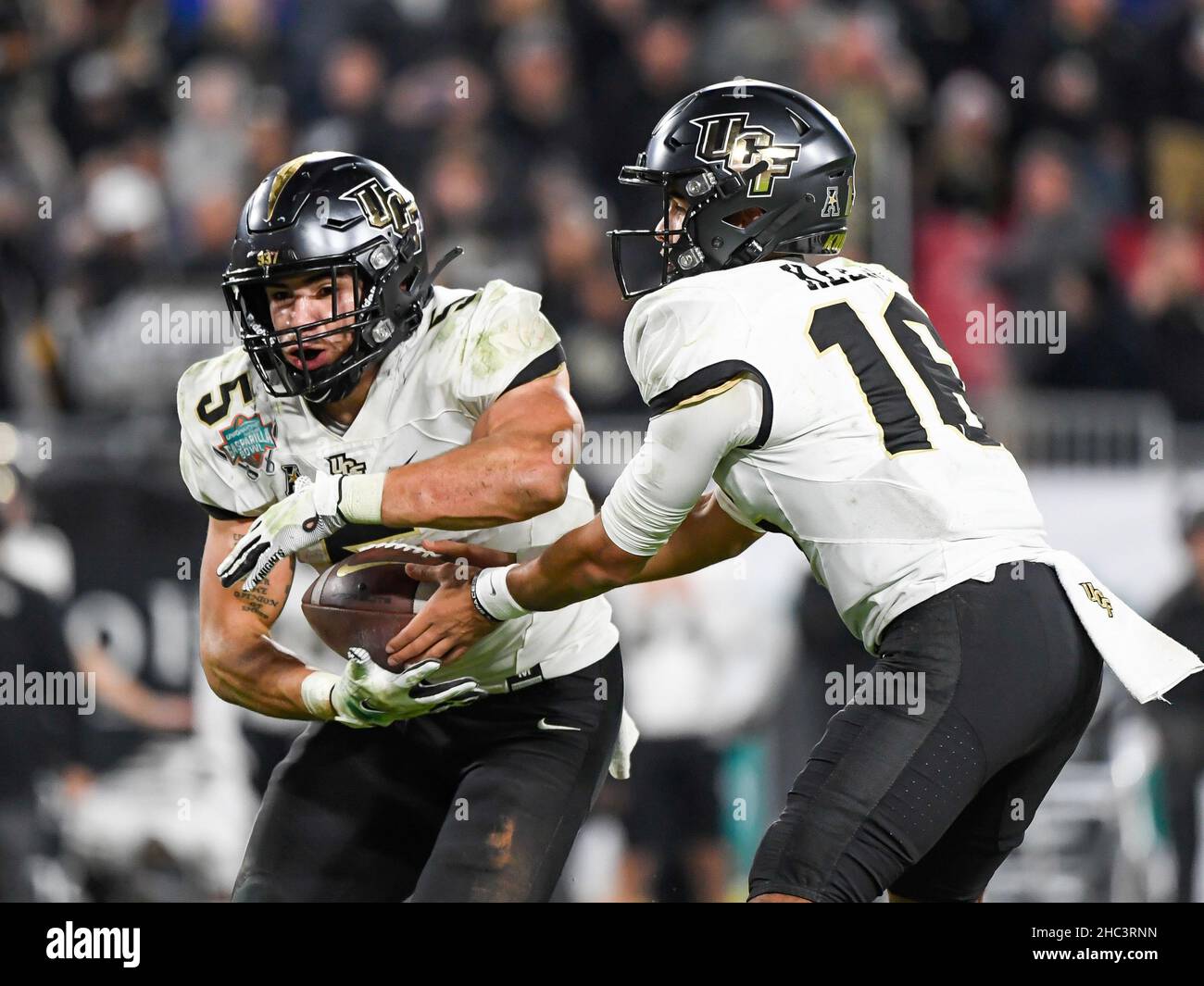 Tampa, FL, USA. 23rd Dec, 2021. UCF Knights quarterback Mikey Keene (16) hands the ball off to UCF Knights running back Isaiah Bowser (5) during the 2nd half of Union Home Mortgage Gasparilla Bowl between the Florida Gators and the UCF Knights. UCF defeated Florida 29-17 at Raymond James Stadium in Tampa, FL. Romeo T Guzman/CSM/Alamy Live News Stock Photo
