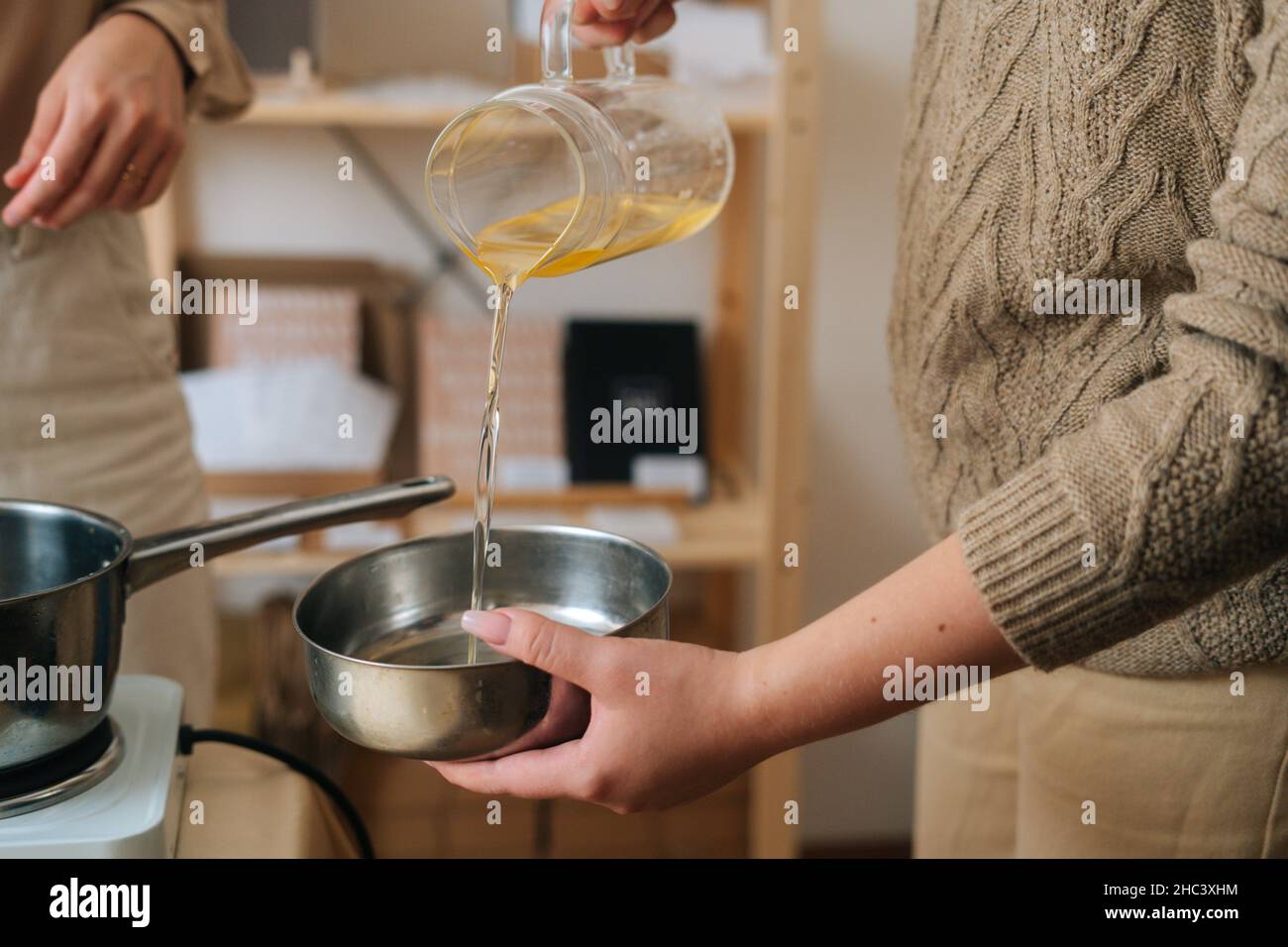 Female Candle Maker Pouring And Measuring Melted Orange Wax Stock Photo by  microgen