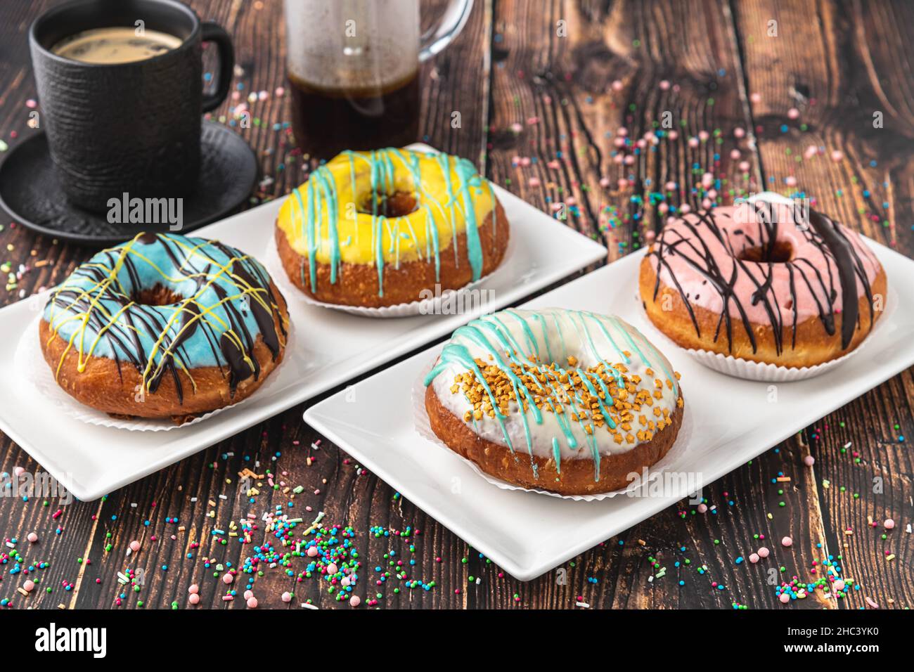 Delicious donuts decorated with different decorations on wooden table Stock Photo