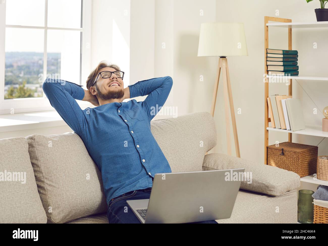 Happy man relax on sofa distracted from computer work Stock Photo