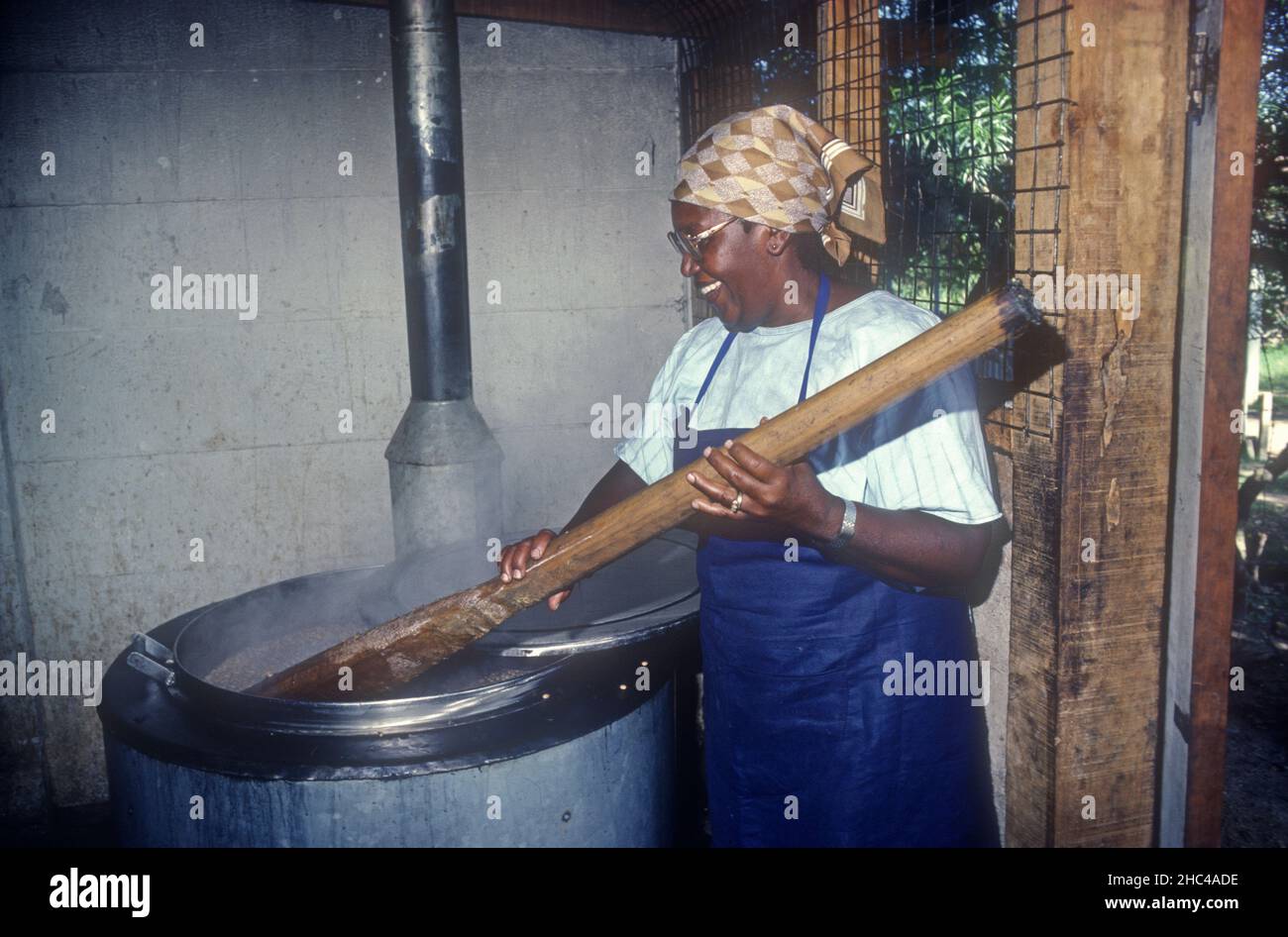 Woman cooking in school kitchen using Bellerive fuel efficient community stove Nairobi Kenya Stock Photo