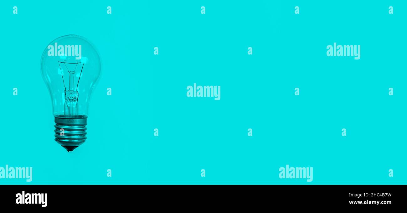Light bulb on a blue background, long banner with space for text. Stock Photo