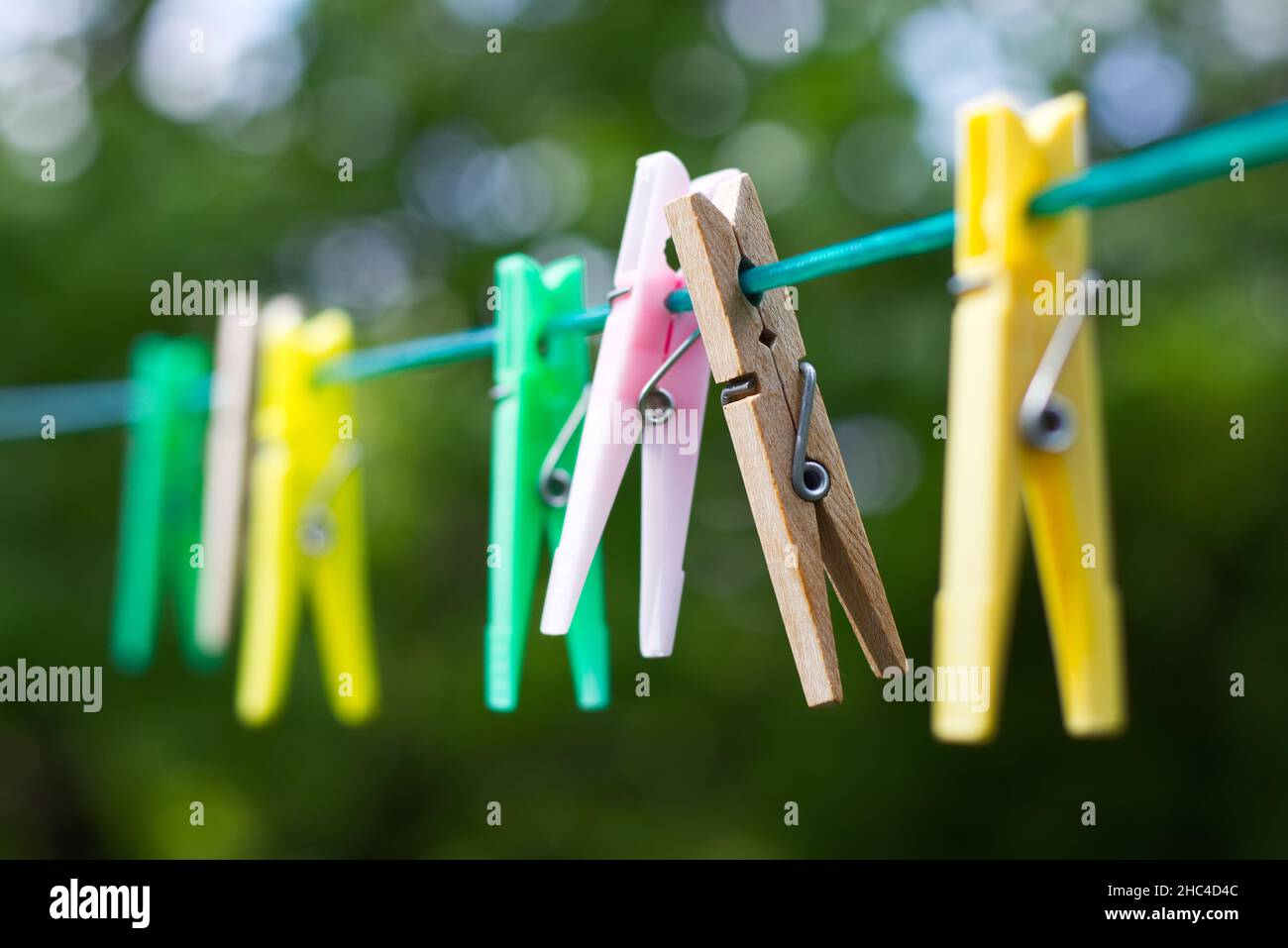 Colored plastic and wooden clothes pegs on the clothesline. Clothes pins in summer day. Stock Photo