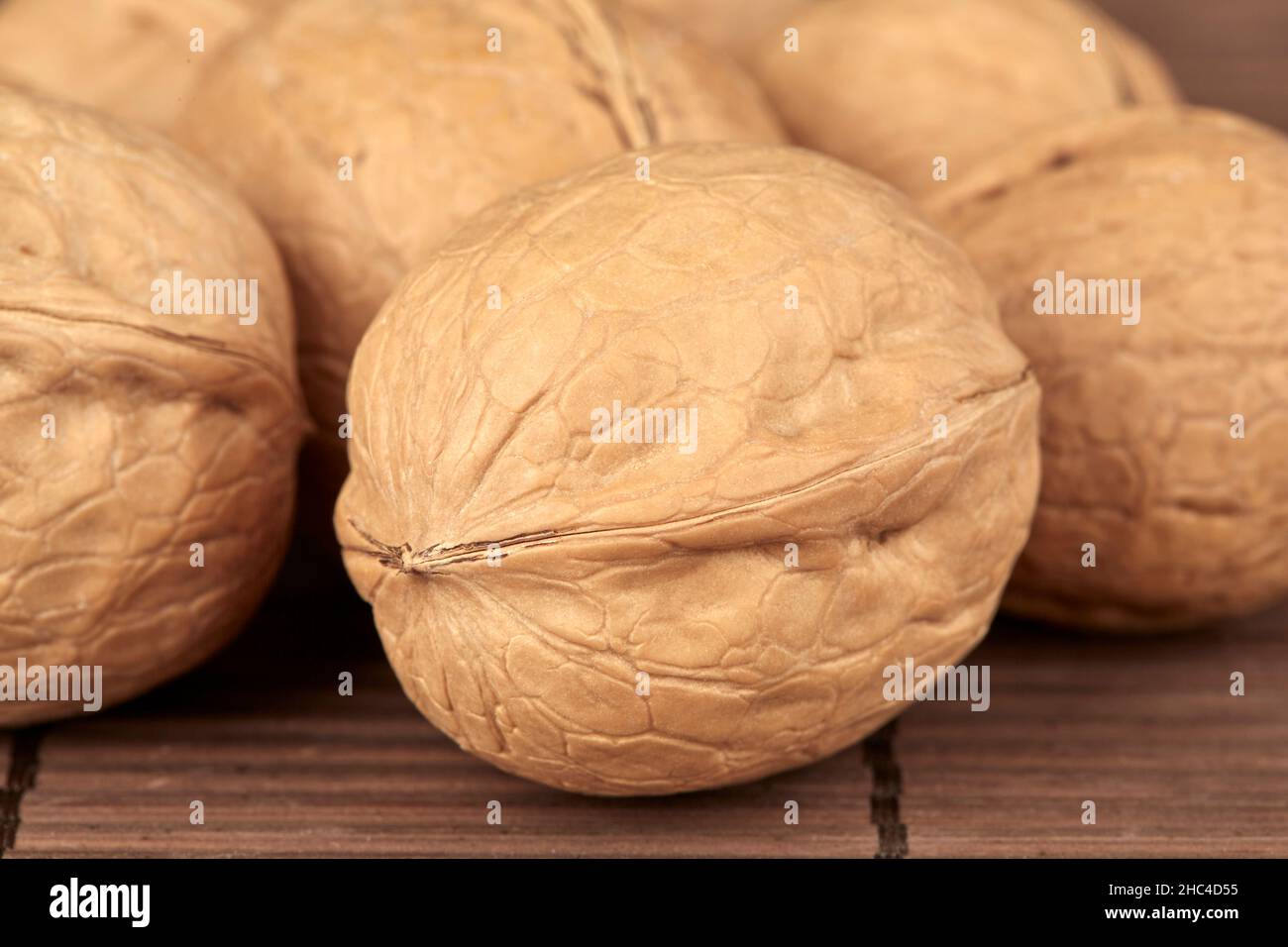 Close-ups of walnuts are lying on the table in a heap. Stock Photo