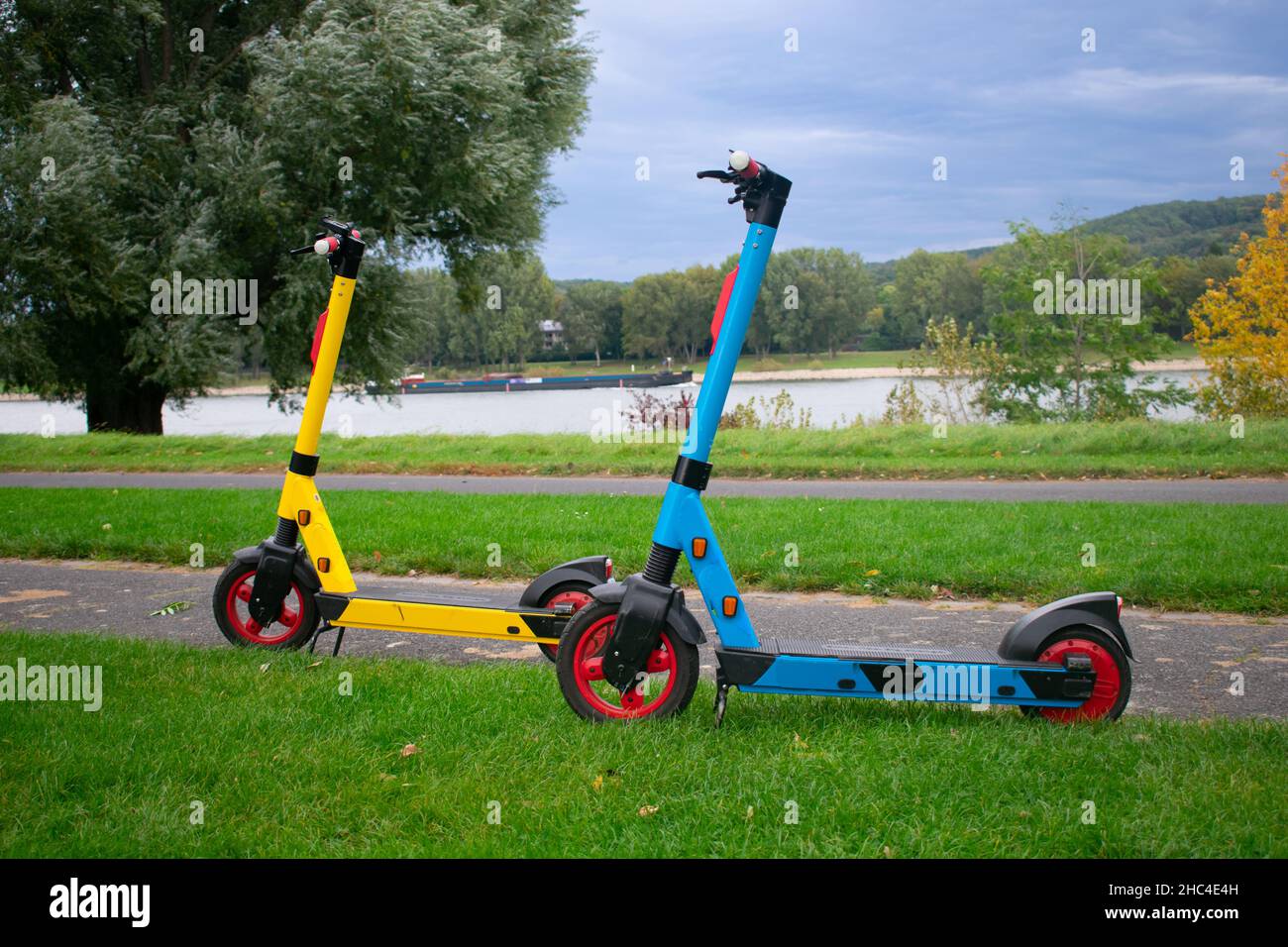 Colorful Electric Scooters in Green City Park – Bonn Germany. European Energy Transition Motif Stock Photo