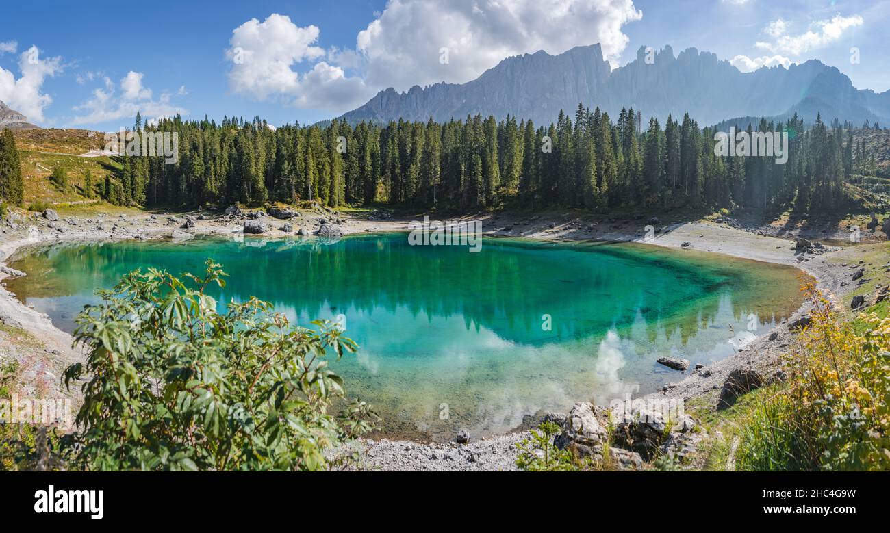 panoramic view of crystal clear karersee with latemar mountains in background Stock Photo