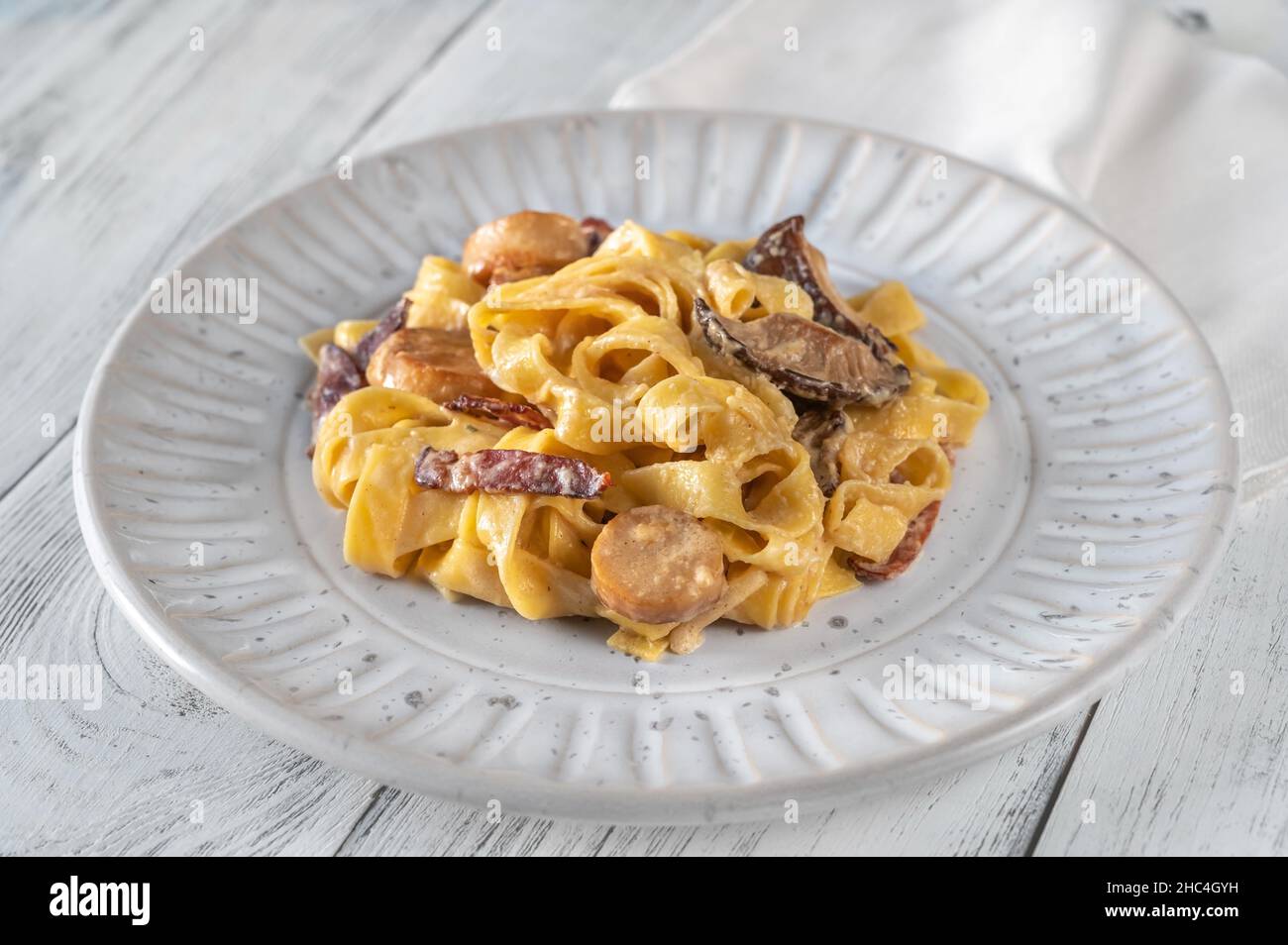 Creamy garlic mushrooms and bacon tagliatelli pasta Stock Photo