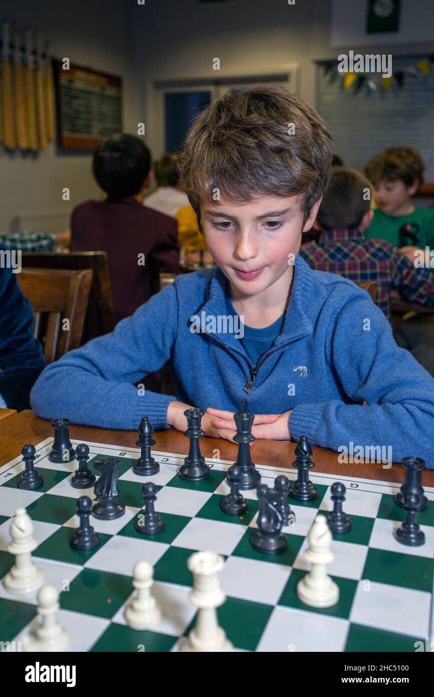 Smart games. A child plays chess. Boy and a chessboard. Strategy. Logical thinking. Stock Photo