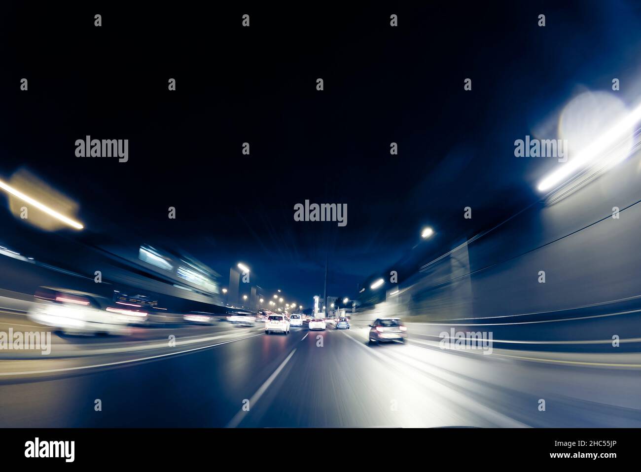 CITY STREET AT NIGHT WITH MOTION BLURRED LIGHTS OF FAST MOVING CARS ...