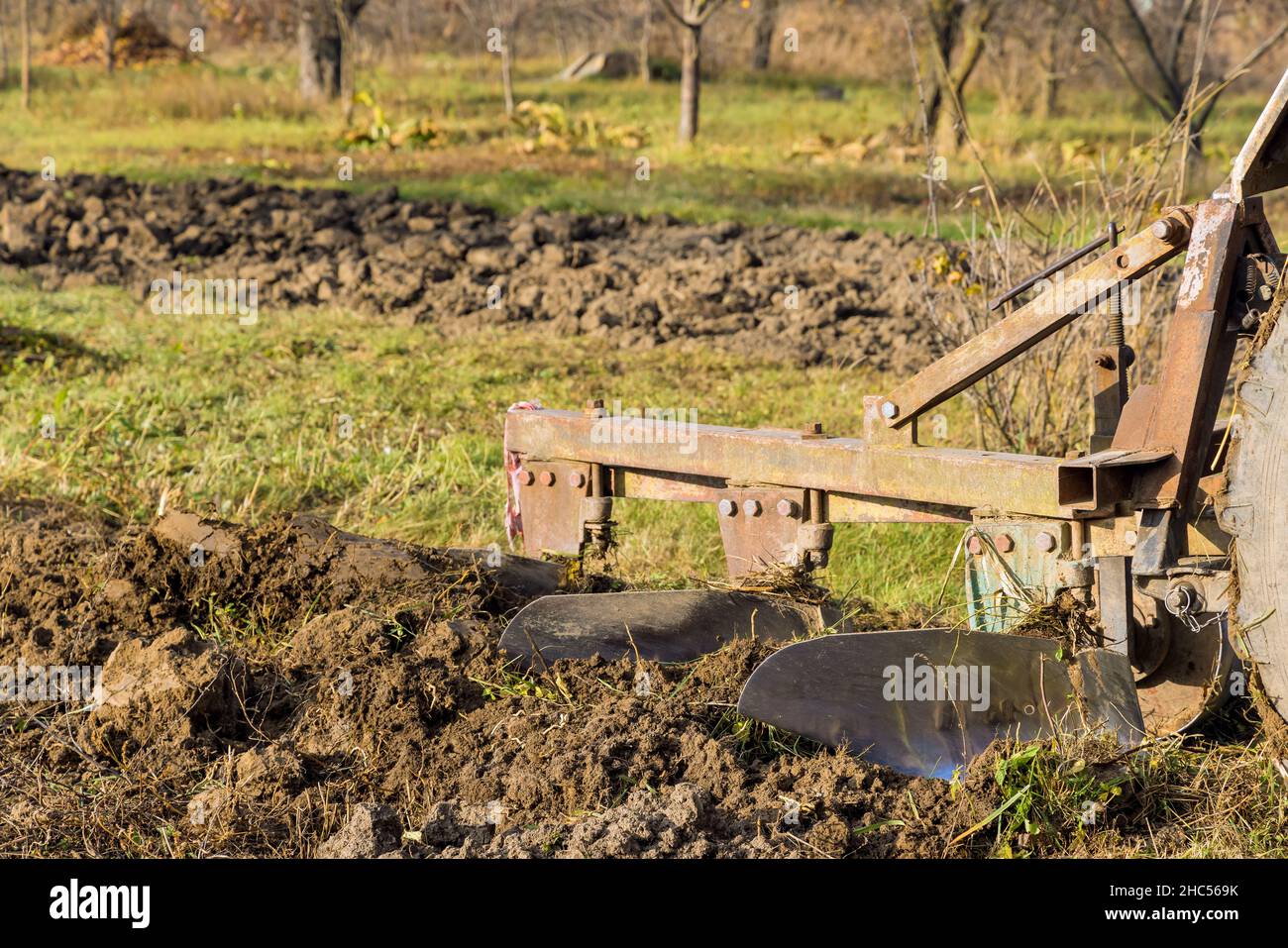 Land cultivation seasonal worker farm tractor plowing field Stock Photo