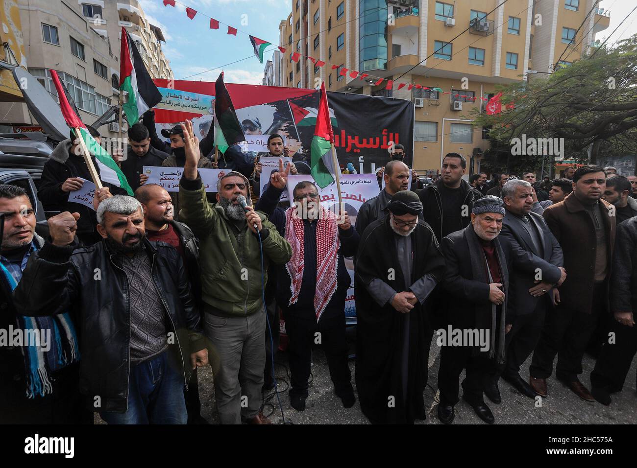 Palestinians perform Friday prayers in front of Red Cross in solidarity with women prisoners in the Israeli prisons, in Gaza City, on Dec 24, 2021. Stock Photo