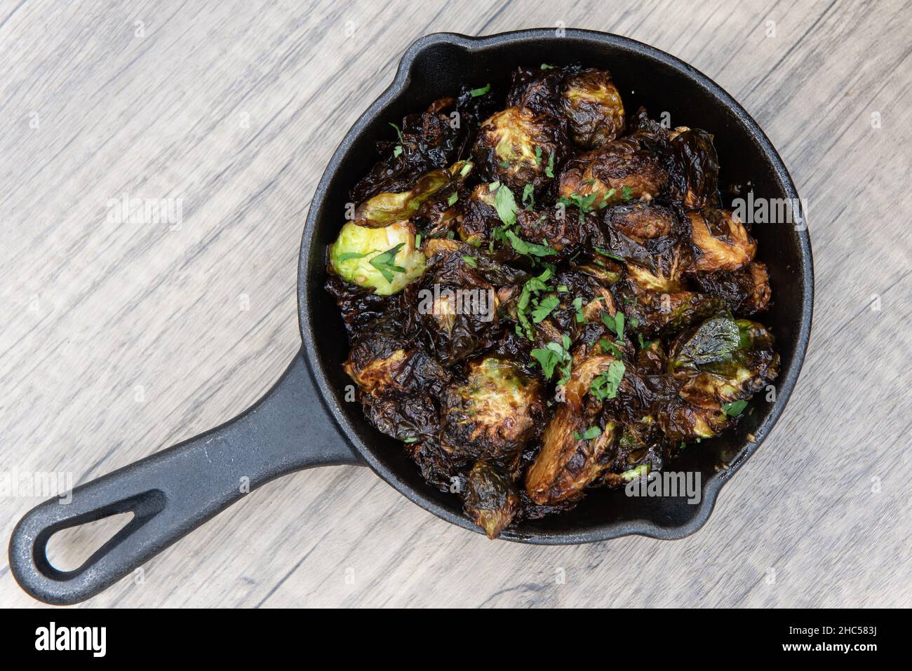 Overhead view of crispy baked brussel sprouts served as finger food to be eaten out of cast iron