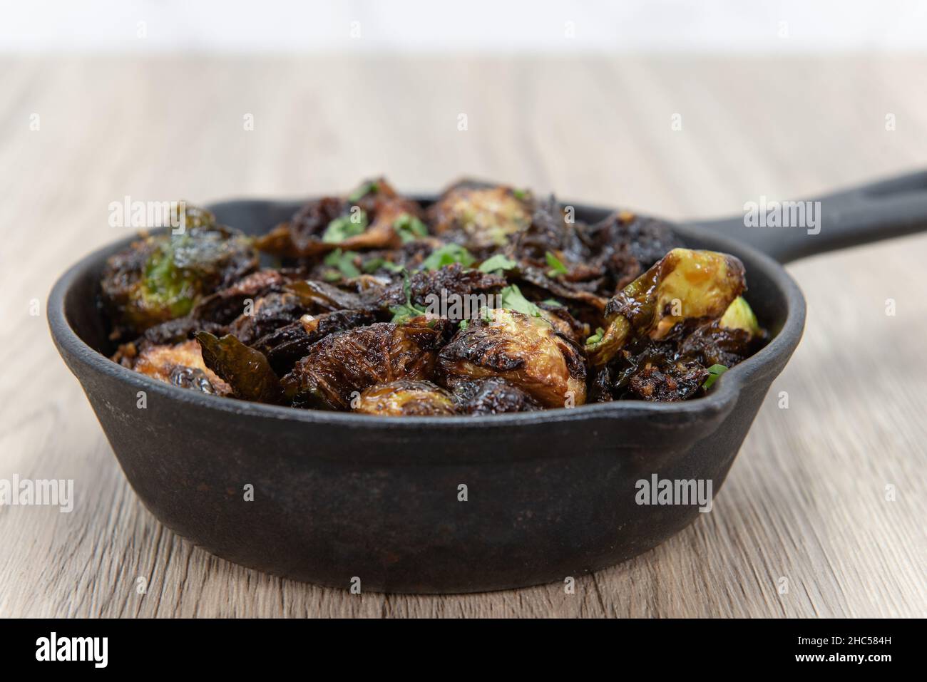 Crispy baked brussel sprouts served as finger food to be eaten out of cast iron pan Stock Photo