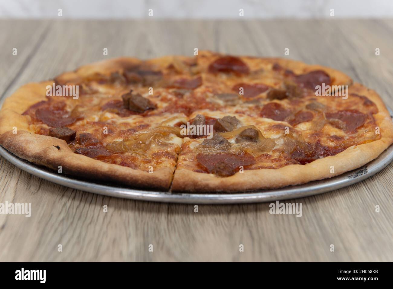 Personal sized Italian pizza with melted cheese, pepperoni, and green ...