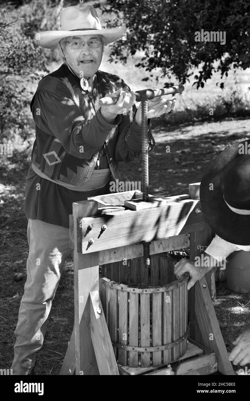 A museum volunteer demonstrates how to make apple cider at El Rancho de las Golondrinas living history complex near Santa Fe, New Mexico. Stock Photo