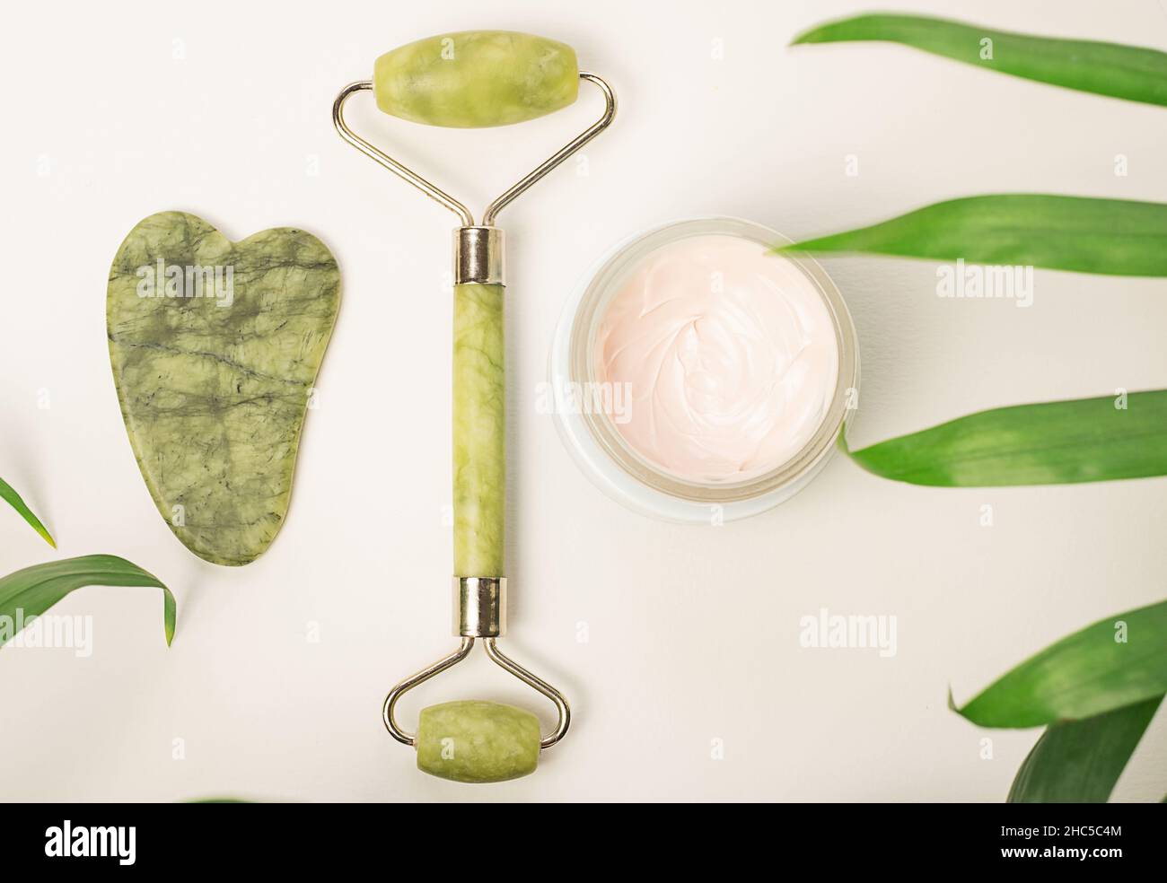 Face care and massage.Face roller with cream on white background Stock Photo