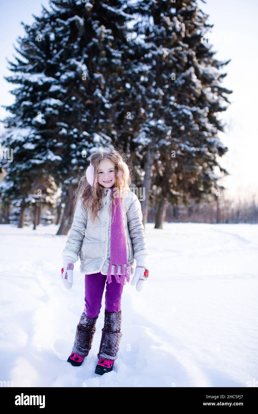 Cute funny kid girl 5 6 year old walk in snowy park over nature