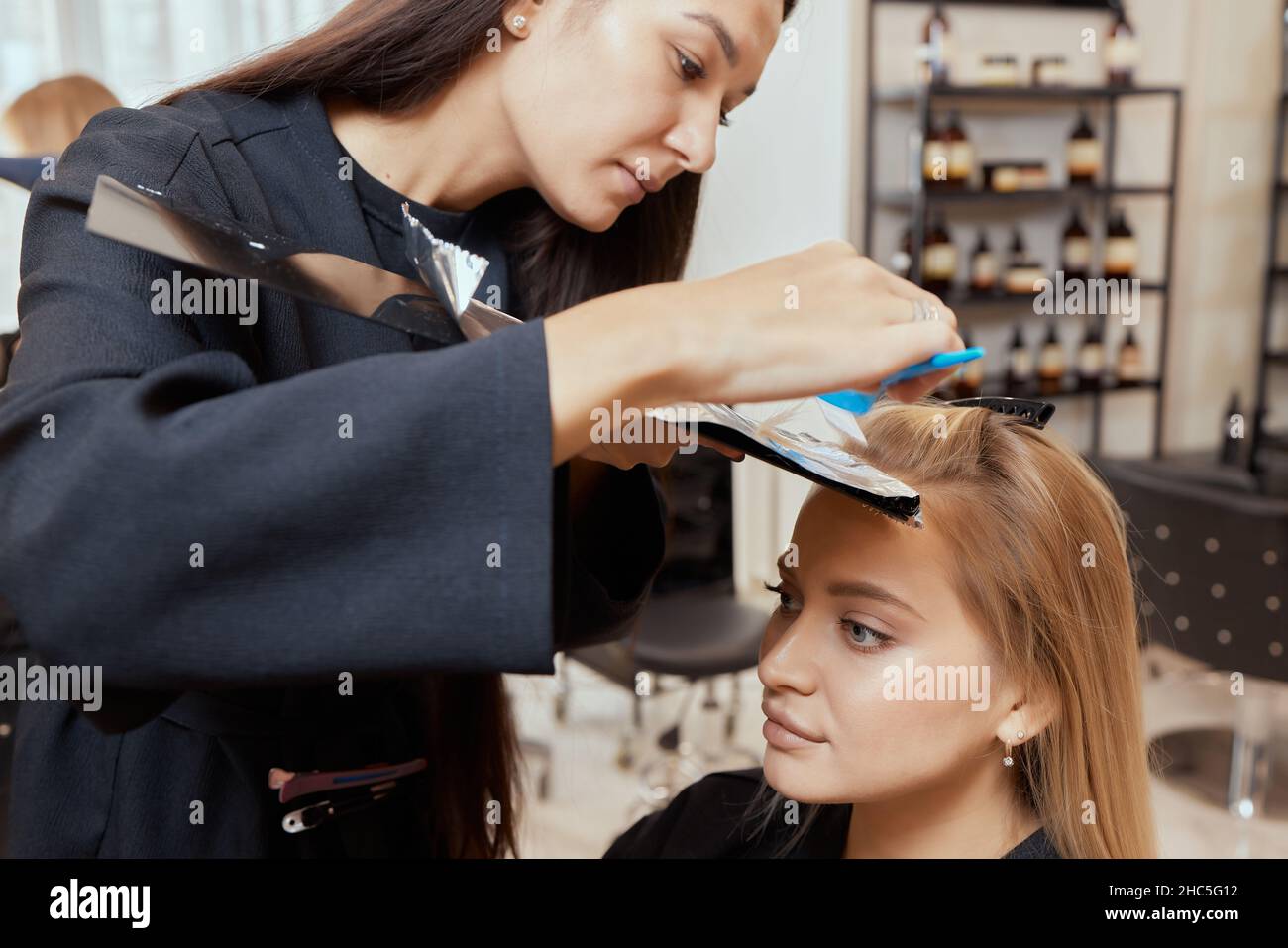 Hair stylist makes bouffant using comb on thin strands. Shatush technique  for hair lightening. Stock Photo by ©vershinin.photo 537875618