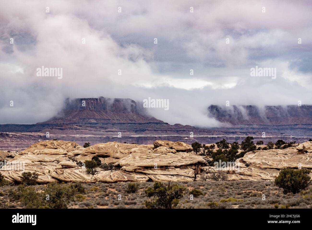 Low Clouds Spill Over The White Rim in Canyonlands National Park Stock Photo