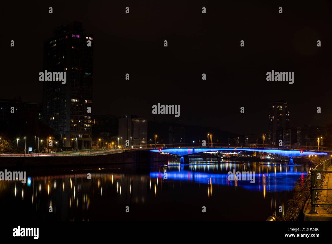 Night view of an illuminated cityscape with buildings and a bridge and ...