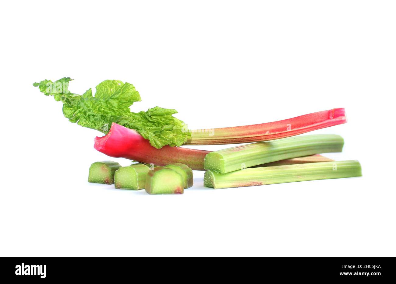 Fresh pieplant. Red and green stems, whole and cut into pieces, petiole with a leaf.  Stock Photo