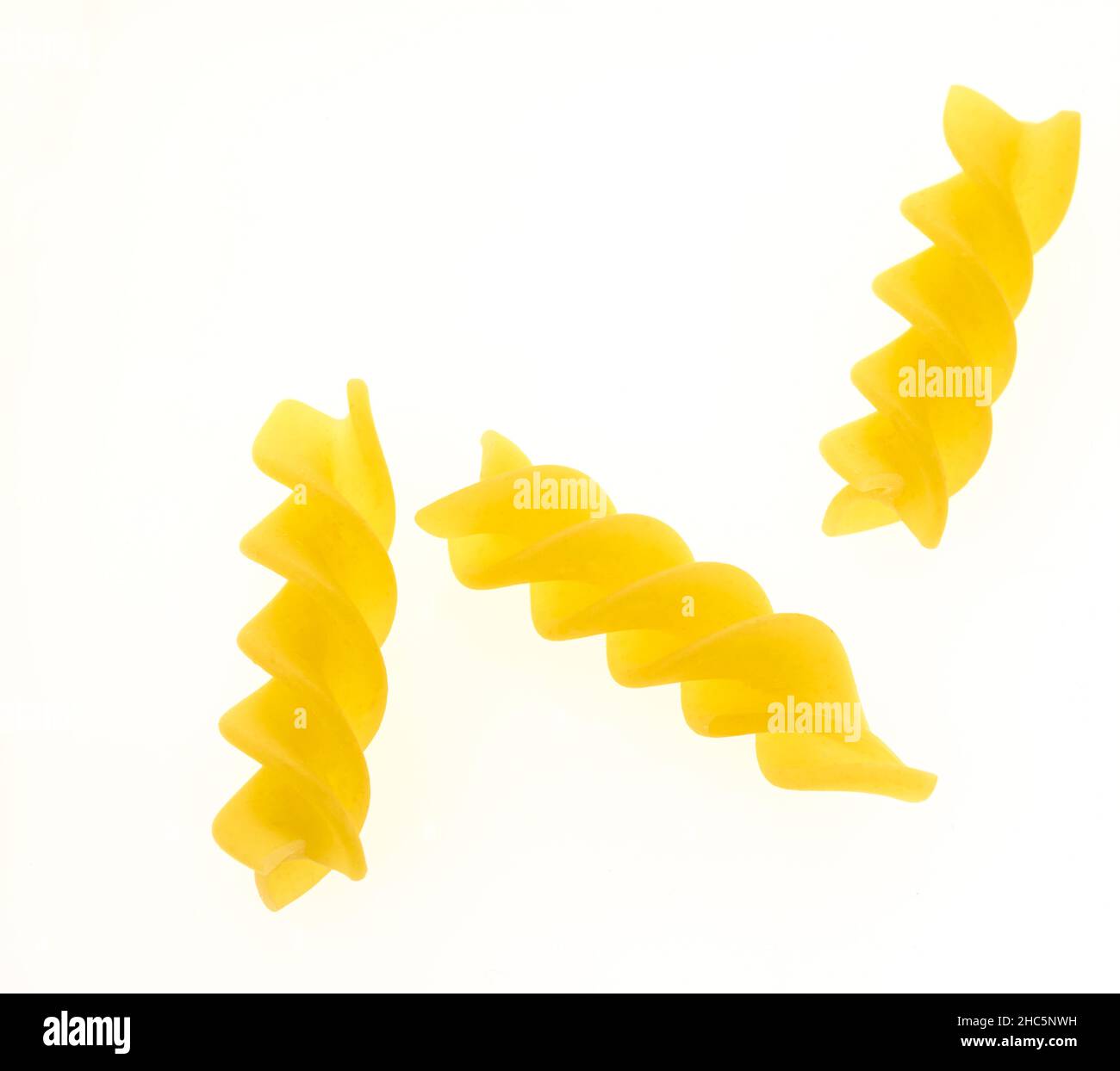 Macro food ingredient of Fusilli, fuˈzilli, pasta, against a plain bac