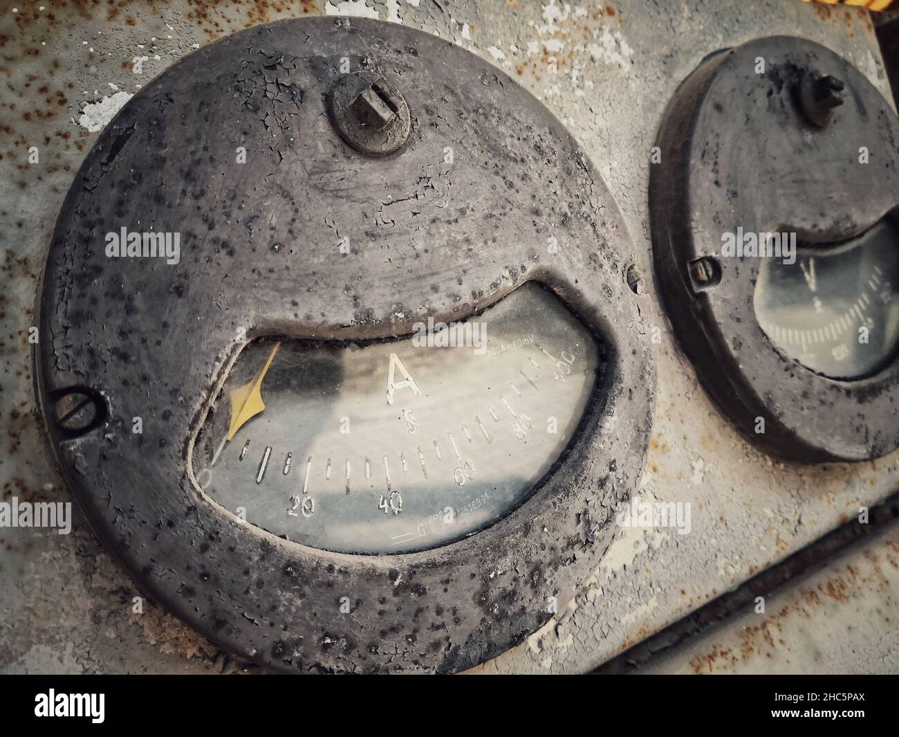 Vintage ancient amperemeter scale, on a rusty abandoned industrial interface. Stock Photo