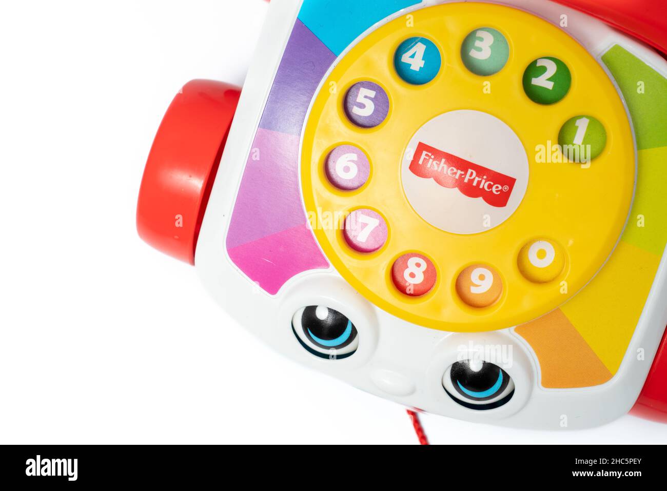 Barcelona, Spain - 12.24.2021: Children's toy landline phone with a red receiver, a dial and a smile on the body made by Fisher-Price isolated on whit Stock Photo
