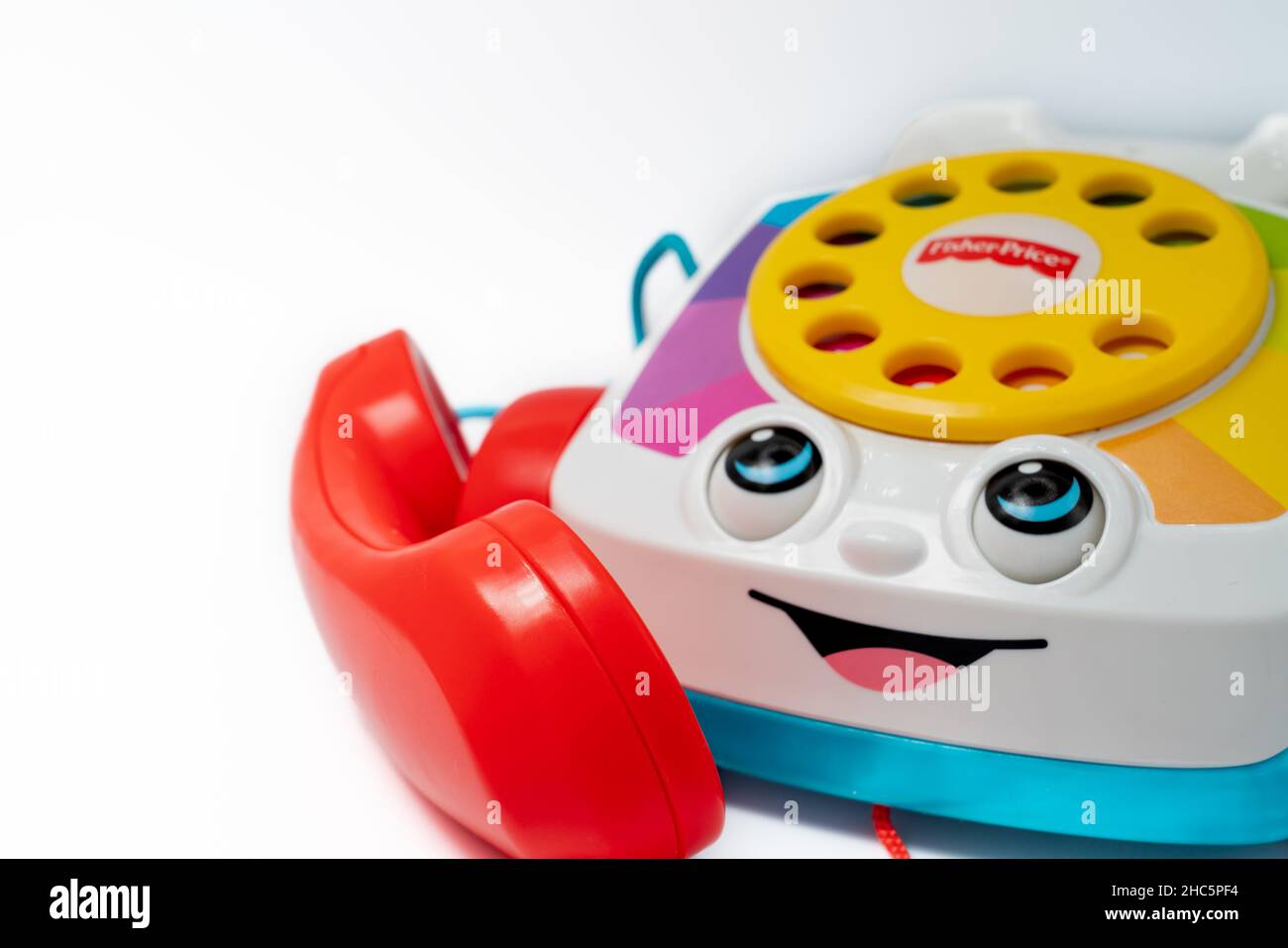 Barcelona, Spain - 12.24.2021: Children's toy landline phone with a red receiver, a dial and a smile on the body made by Fisher-Price isolated on whit Stock Photo