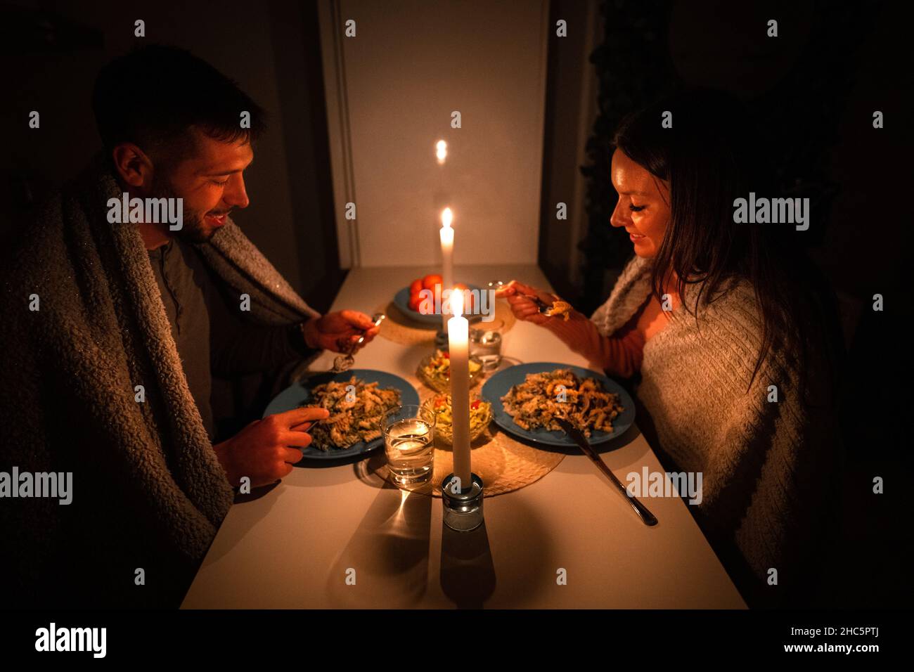 Couple having dinner at home during power outage. Blackout, no electricity Stock Photo
