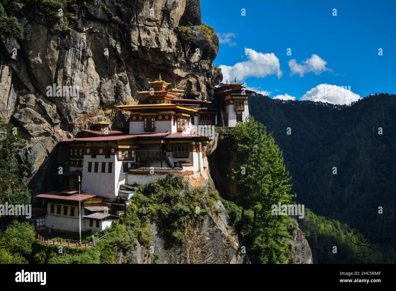 Aerial shot of the beautiful Taktsang Palphug Monastery in Paro, Bhutan surrounded by greenery Stock Photo