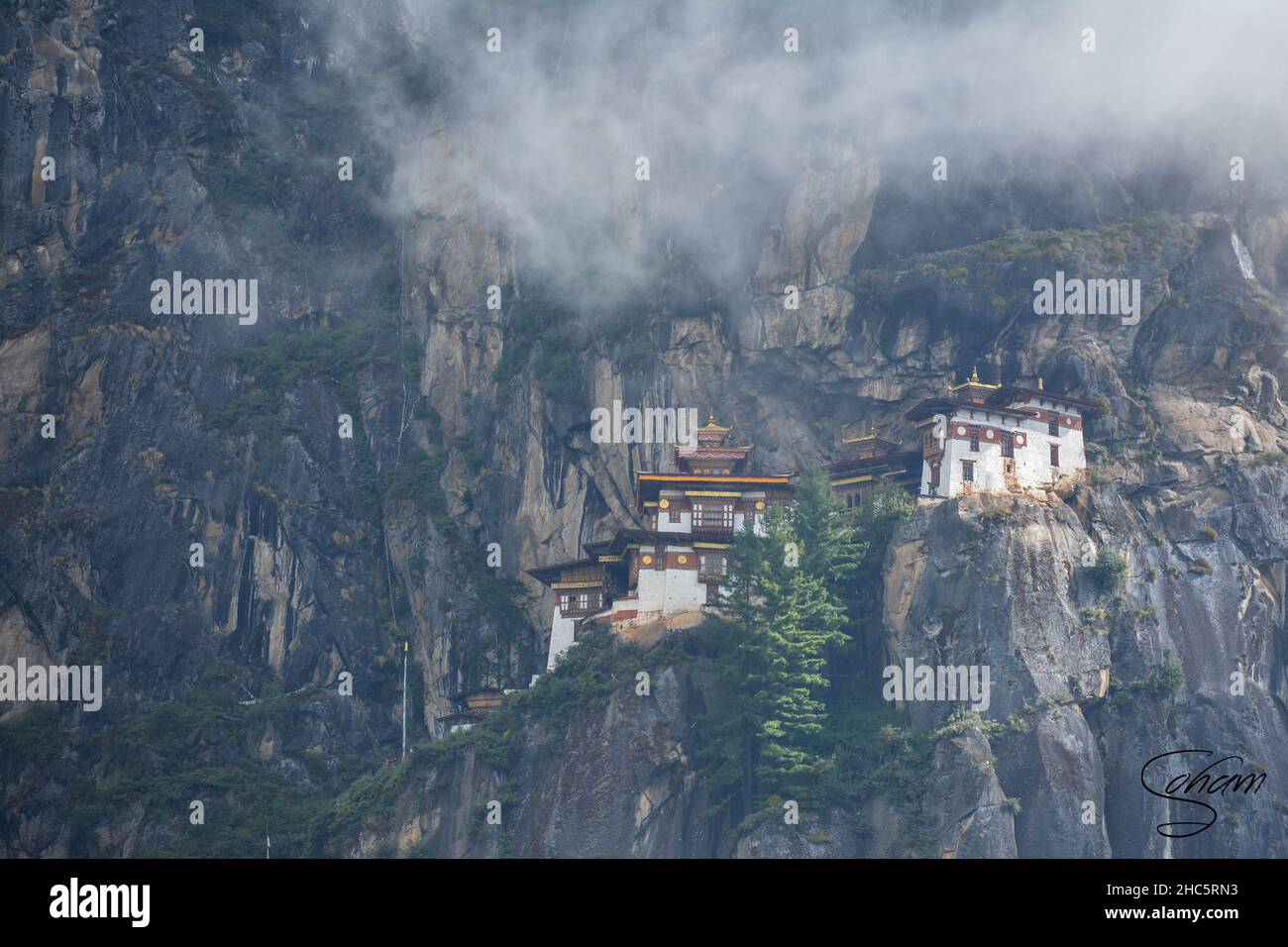 Aerial view of the beautiful Taktsang Palphug Monastery in Paro, Bhutan with fog everywhere Stock Photo