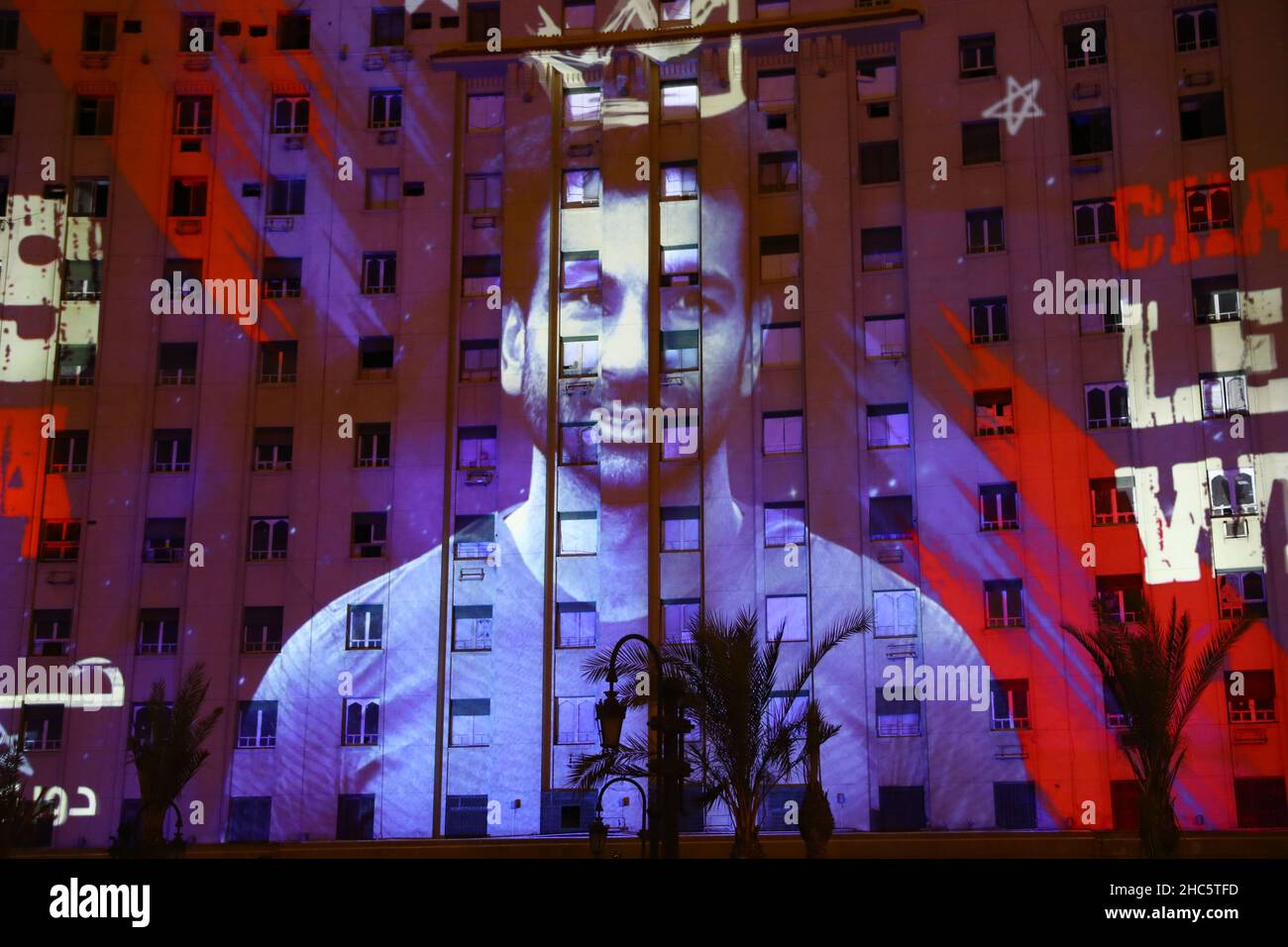 Cairo. 24th Dec, 2021. Photo taken on Dec. 24, 2021 shows the 3D mapping of Egyptian professional footballer Mohamed Salah on Tahrir Complex building in Cairo, Egypt. The mapping show held on Friday night exhibited Mohamed Salah's some most remarkable achievements, such as breaking England's football score record with his 100 goals, winning the Champions League in 2019 and his recognition as the 1st Player in Africa. Salah is an Egyptian professional footballer who captains Egypt national football team and plays for Liverpool Football Club. Credit: Ahmed Gomaa/Xinhua/Alamy Live News Stock Photo