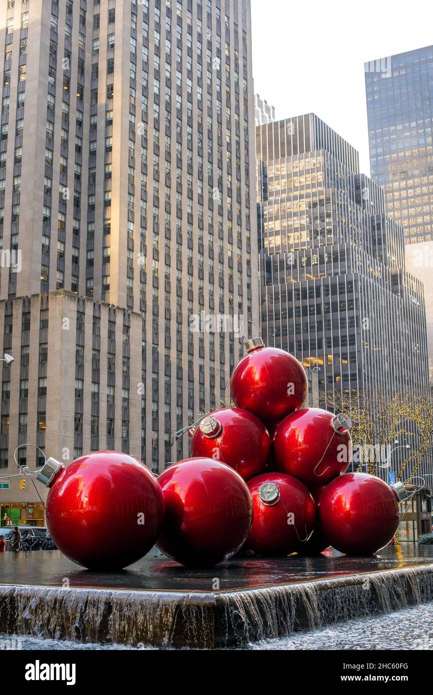 New York, USA. 22nd Dec, 2021. Giant Christmas Ornaments at 1251 Sixth Avenue, New York City. It's across from Radio City Music Hall. Giant red ornament balls sit on a fountain which is surrounded by trees ensconced in holiday lights. (Credit Image: © Shawn Goldberg/SOPA Images via ZUMA Press Wire) Stock Photo
