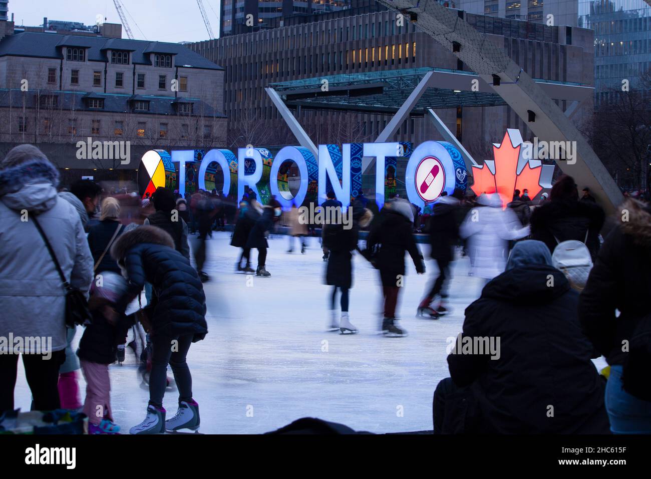 Toronto, December 24, 2021 -  People ice skating  at Nathan Square Phillips on Christmas Eve Stock Photo