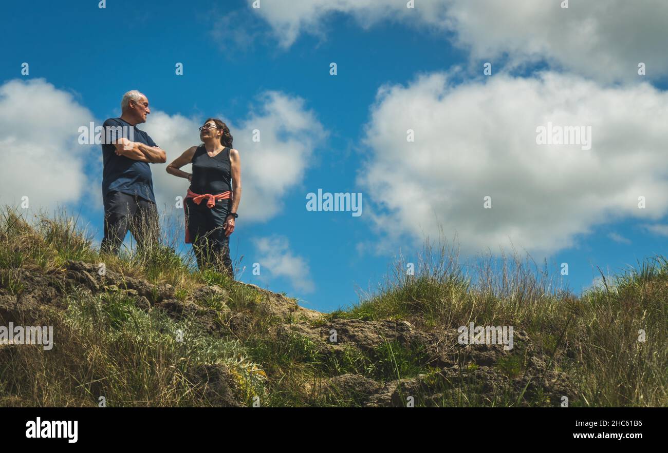 Old couple standing on the top of the hill after hiking Stock Photo - Alamy