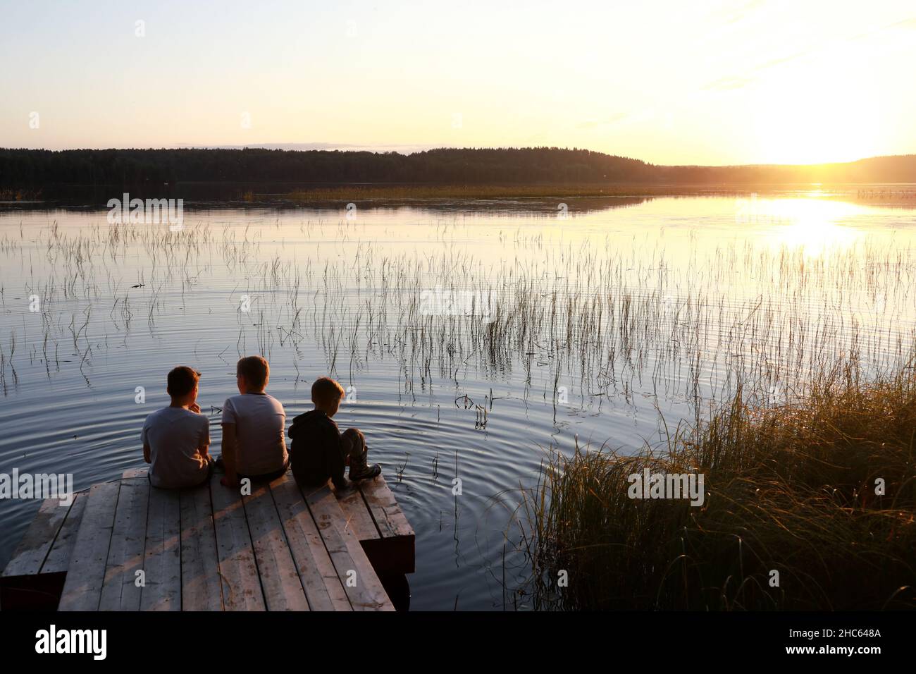 Three children sitting on bridge hi-res stock photography and images ...