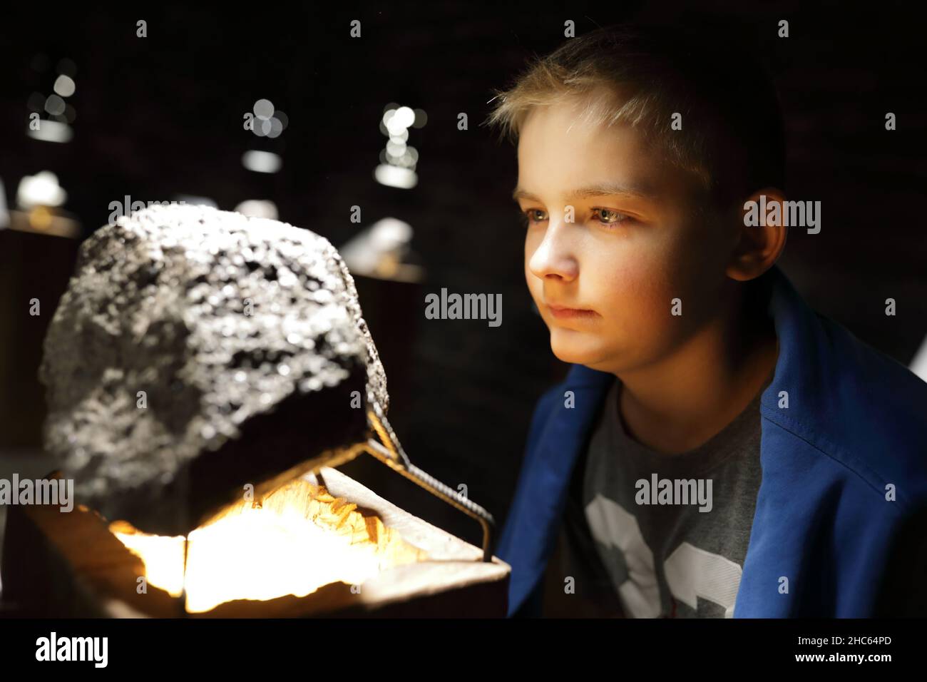 Kid examines natural mineral in Geological Museum Stock Photo