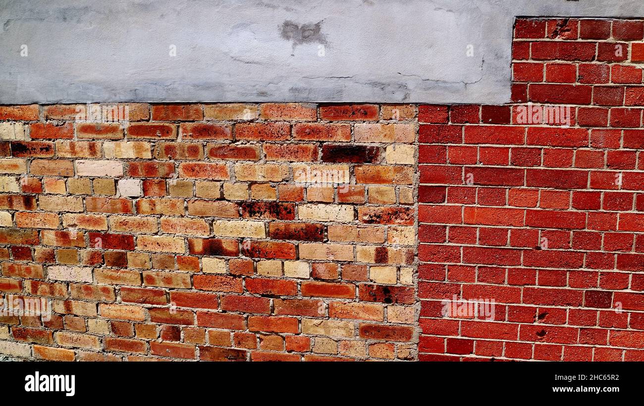 Close up of a heritage wall with concrete, old vintage bricks and new