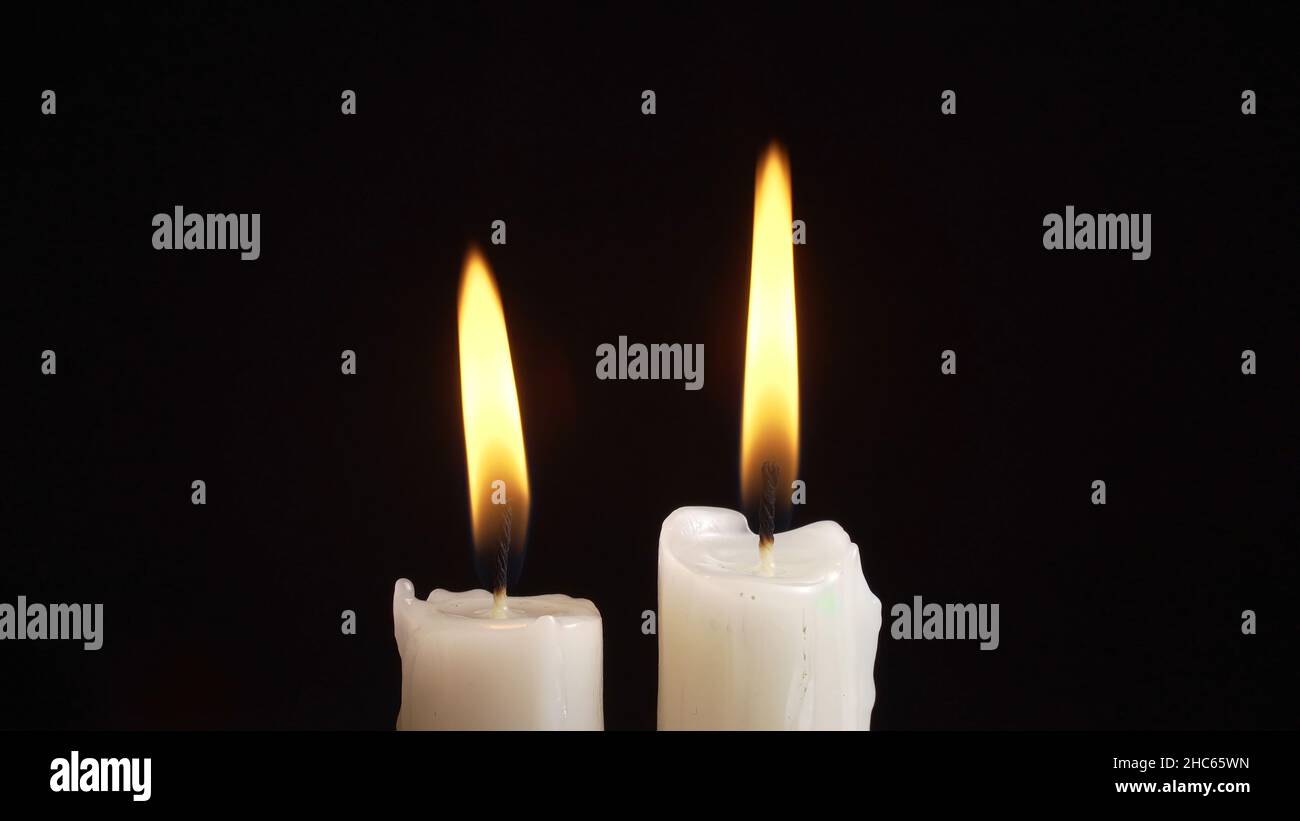 Photo of burning a two candles on black background Stock Photo - Alamy
