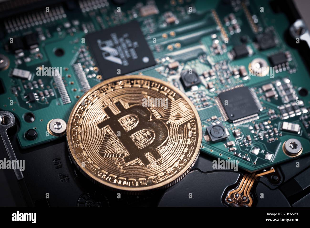 one bitcoin coin lies on a computer board Stock Photo