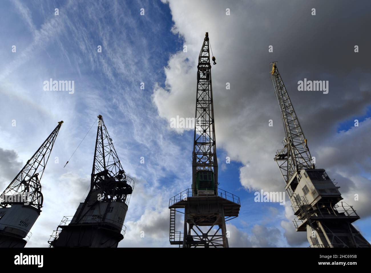 Low angle shot of construction cranes under a cloudy sky - port of ...