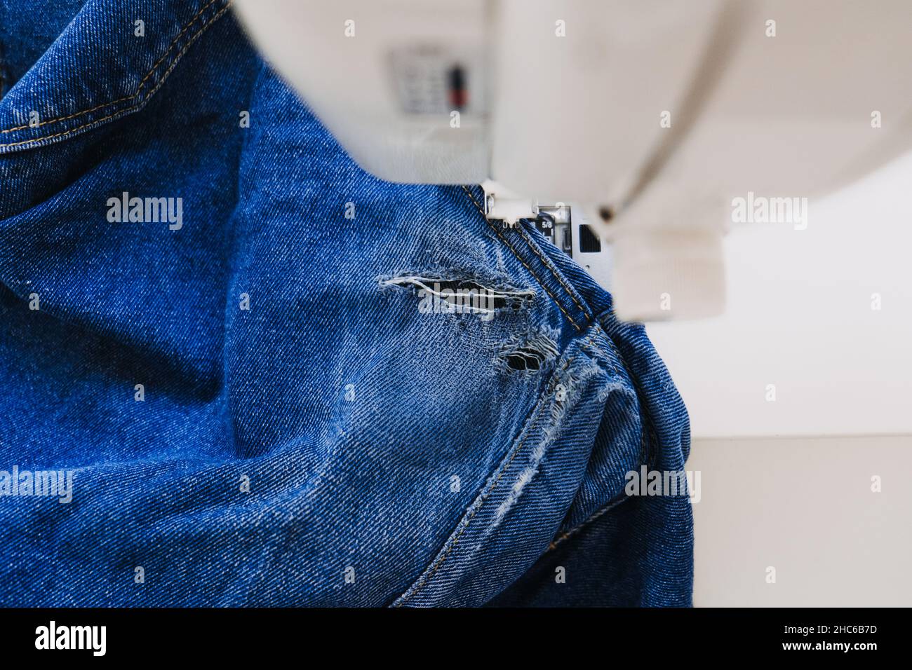 Reuse, repair, upcycle. Denim upcycling ideas, repair and using old jeans.  Close-up of sewing machine with shabby, old, torn denim jeans fabric Stock  Photo - Alamy
