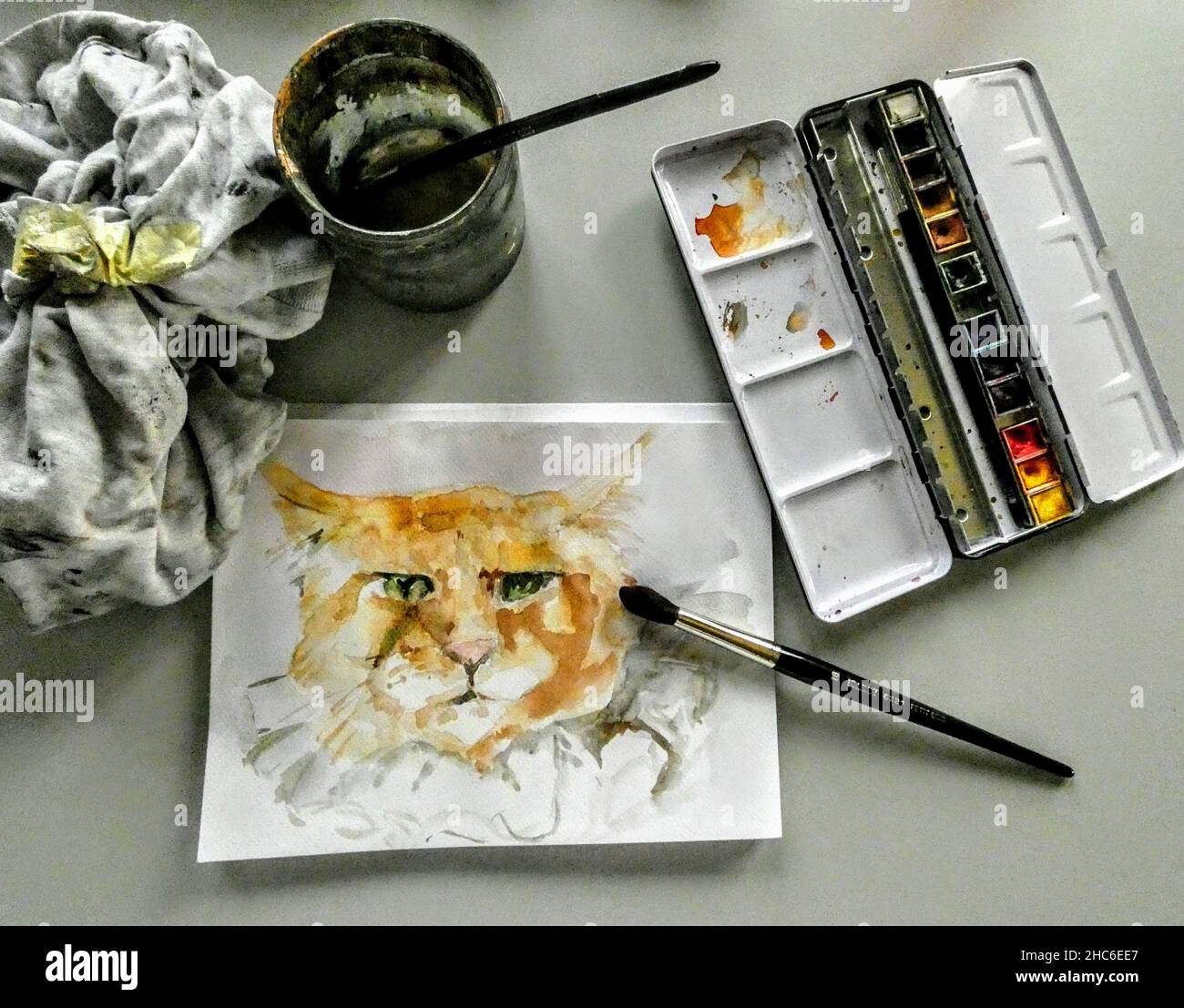 Top view of a watercolor cat painting with brush and palette on a table Stock Photo