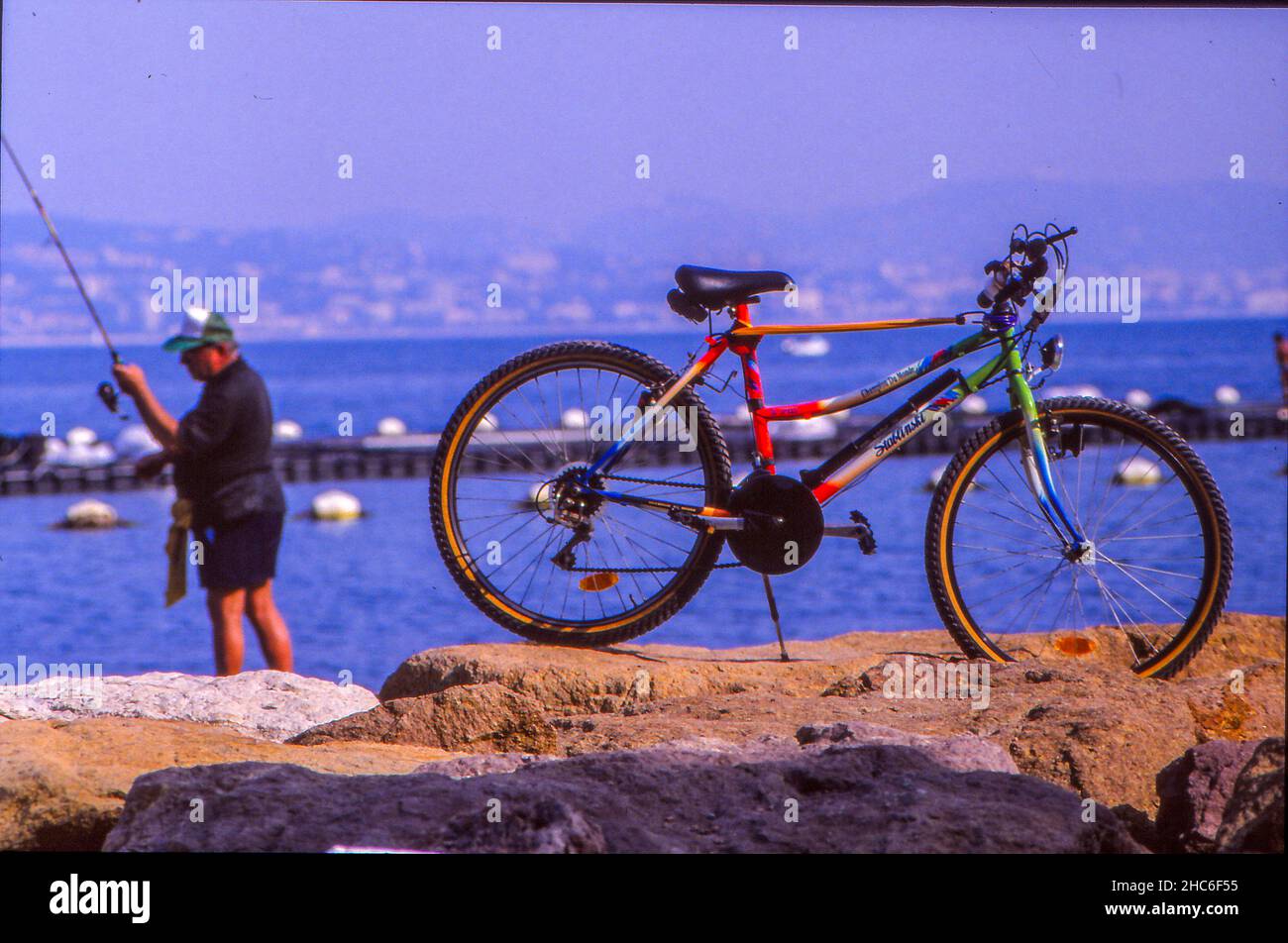 Bicycling sport at the mediterranean sea, Fahrrad am Mittelmeer mit Angler Stock Photo