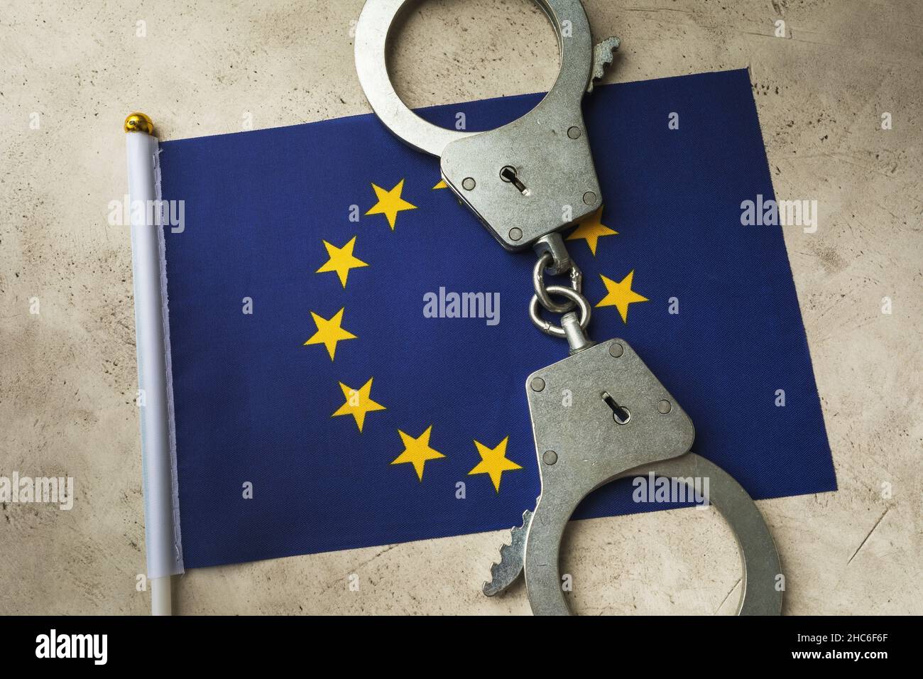 EU flag and handcuffs on an abstract background, the concept of crime in the European society Stock Photo