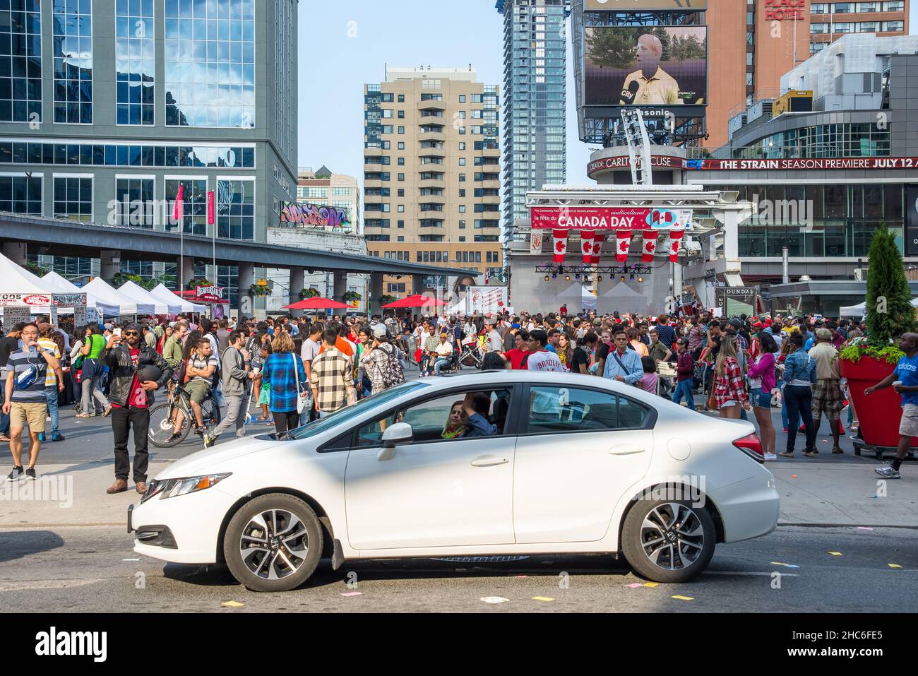 People crowd in Dundas Square the streets during Canada Day. Canada Day is celebrated annually and is a national holiday. Stock Photo