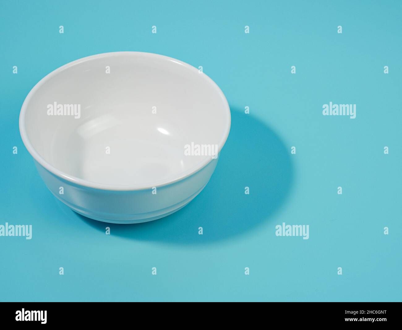 empty white bowl on blue background. minimalist style. Stock Photo