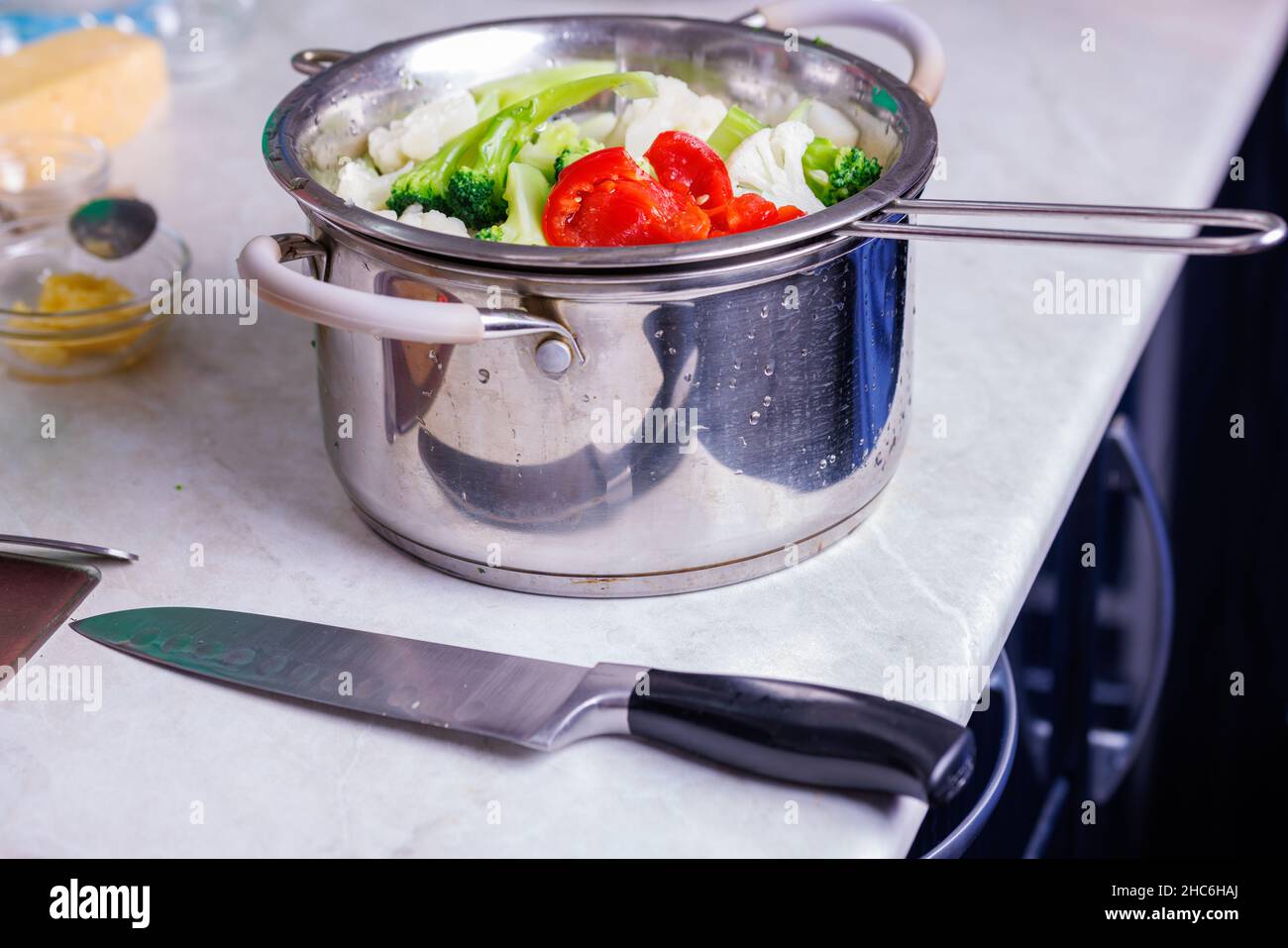 chopped boiled vegetables in colander in stainless steel cooking pot ...