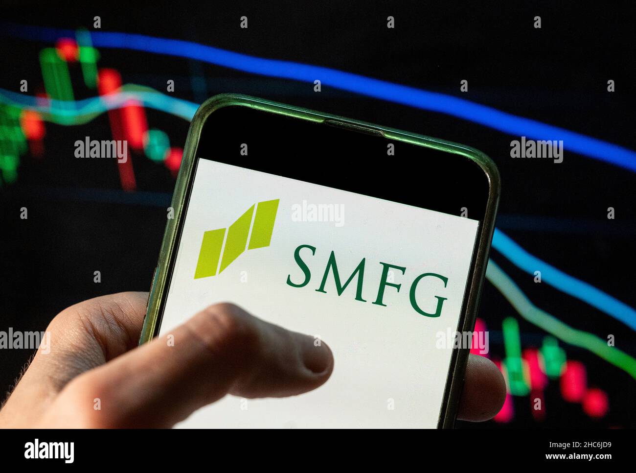 In this photo illustration the Japanese multinational banking and financial company Sumitomo Mitsui Financial Group SMFG logo seen displayed on a smartphone with an economic stock exchange index graph in the background. Stock Photo